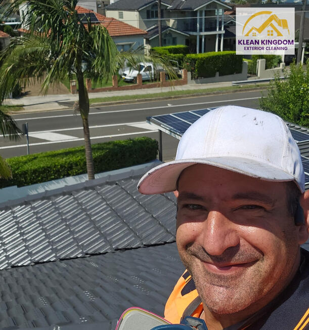 Klean Kingdom's owner on top of the finished roof after a terracotta roof paint restoration in Kogarah Bay, Sydney — coated with IRC roof membrane Klean Kingdom owner standing on a completed terracotta roof restoration in Kogarah Bay, Sydney, coated with IRC roof membrane